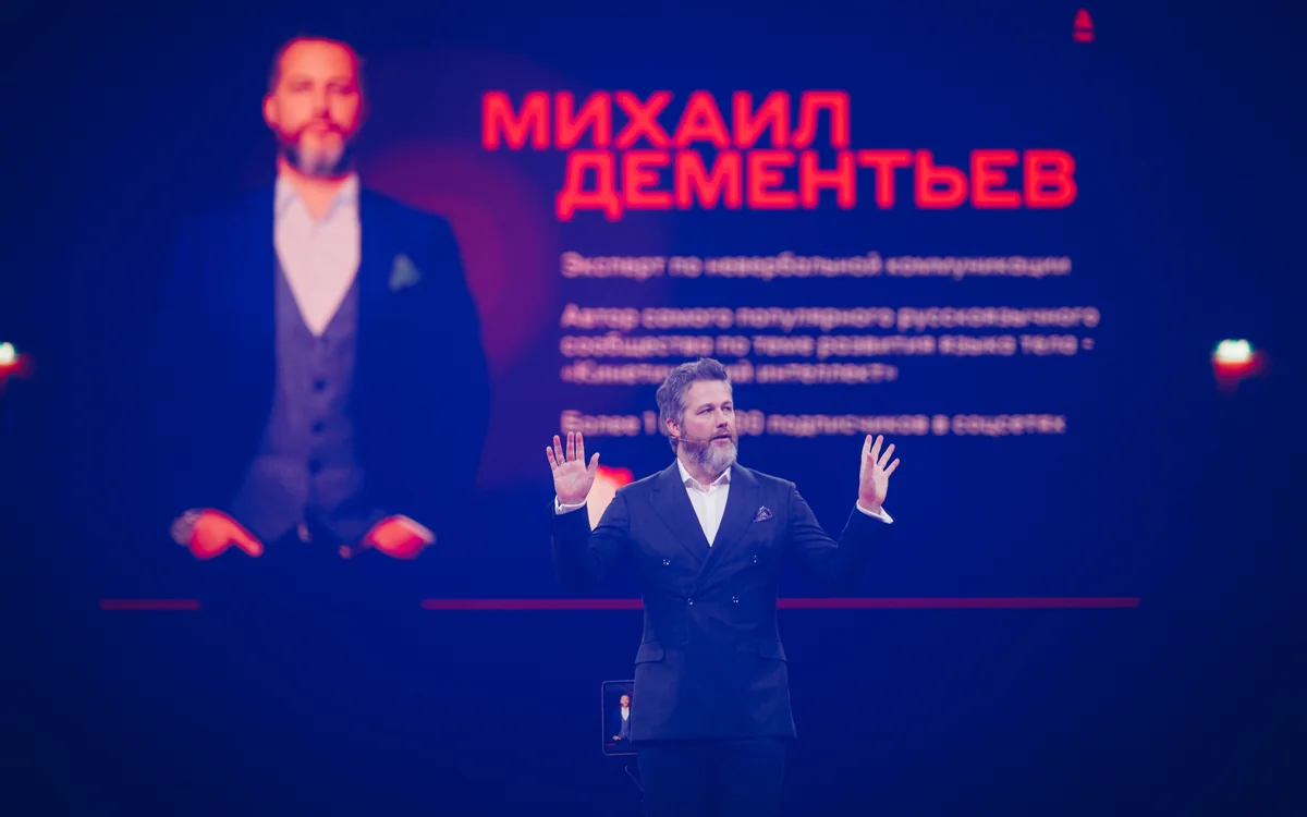 Михаил Дементьев на большой сцене, за спиной — слайд с его представлением